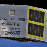 A rendering of a TACHELES cube satellite floating in space above Earth. It appears mostly encased in metal with some various open-air sensors on some sides.