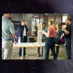 Coworkers playing a game of Jenga in the building 3 collaboration area at JSC.