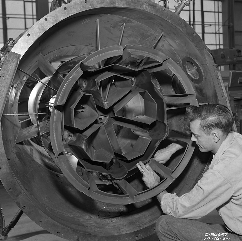 A mechanic works on engine.