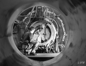 View through test cellof man looking at engine.