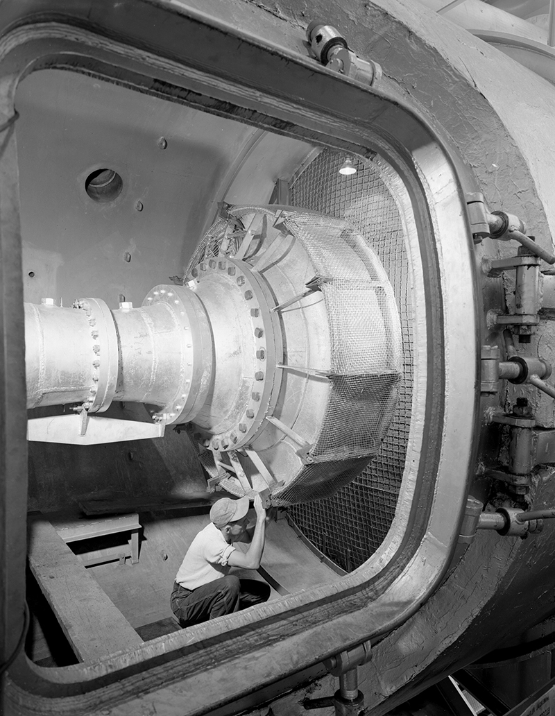 Man in test cell looking at hardware.