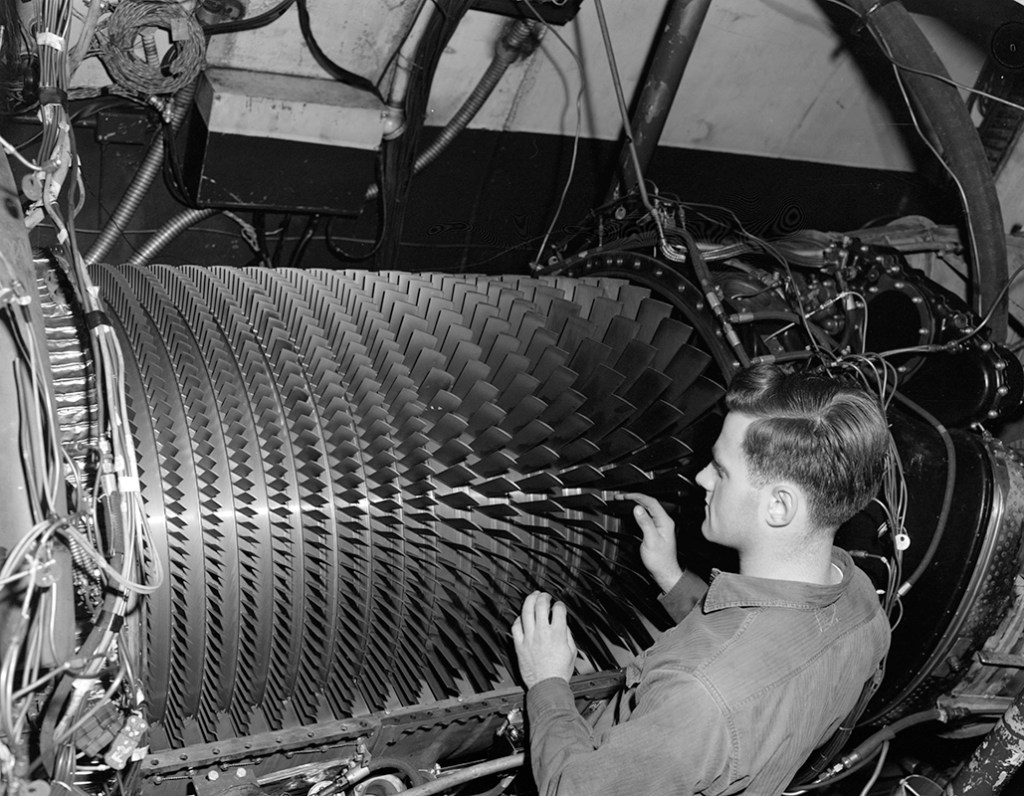 A mechanic examines the compressor