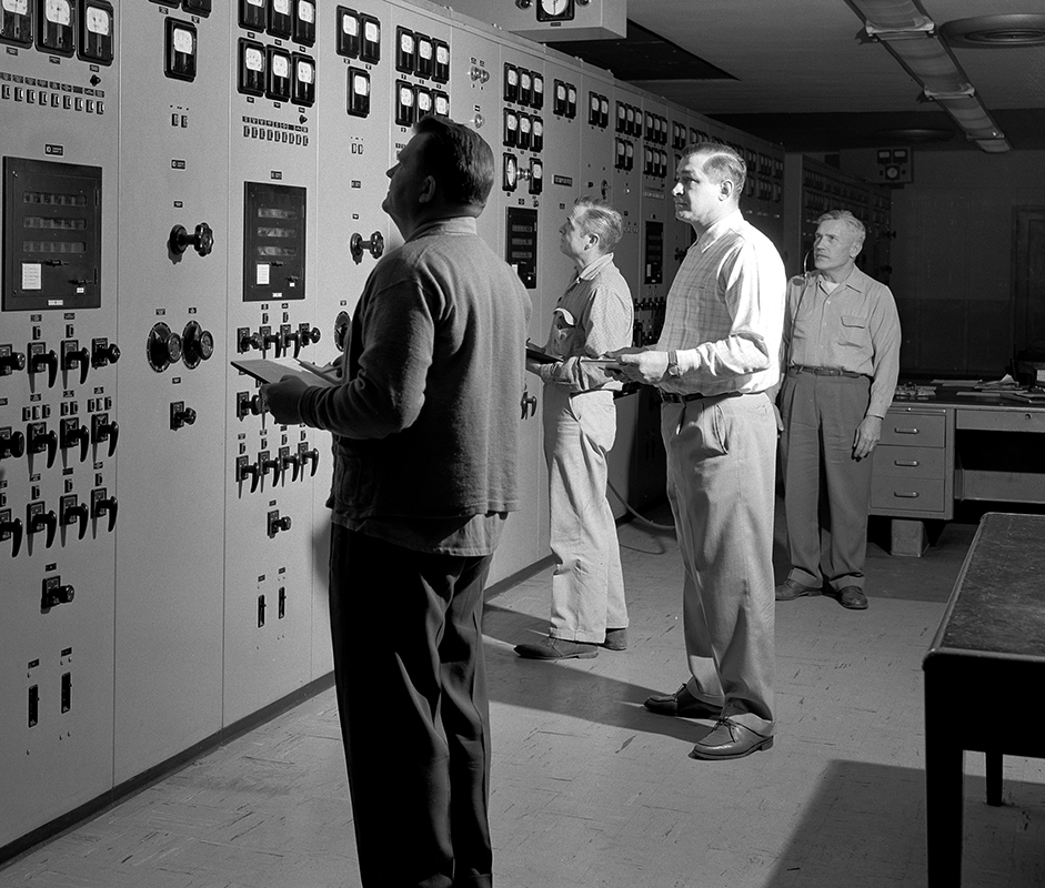 Men looking at control panels.