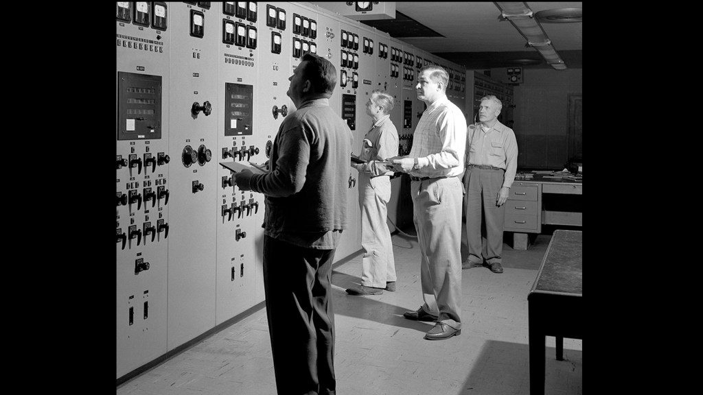 Men looking at control panels.