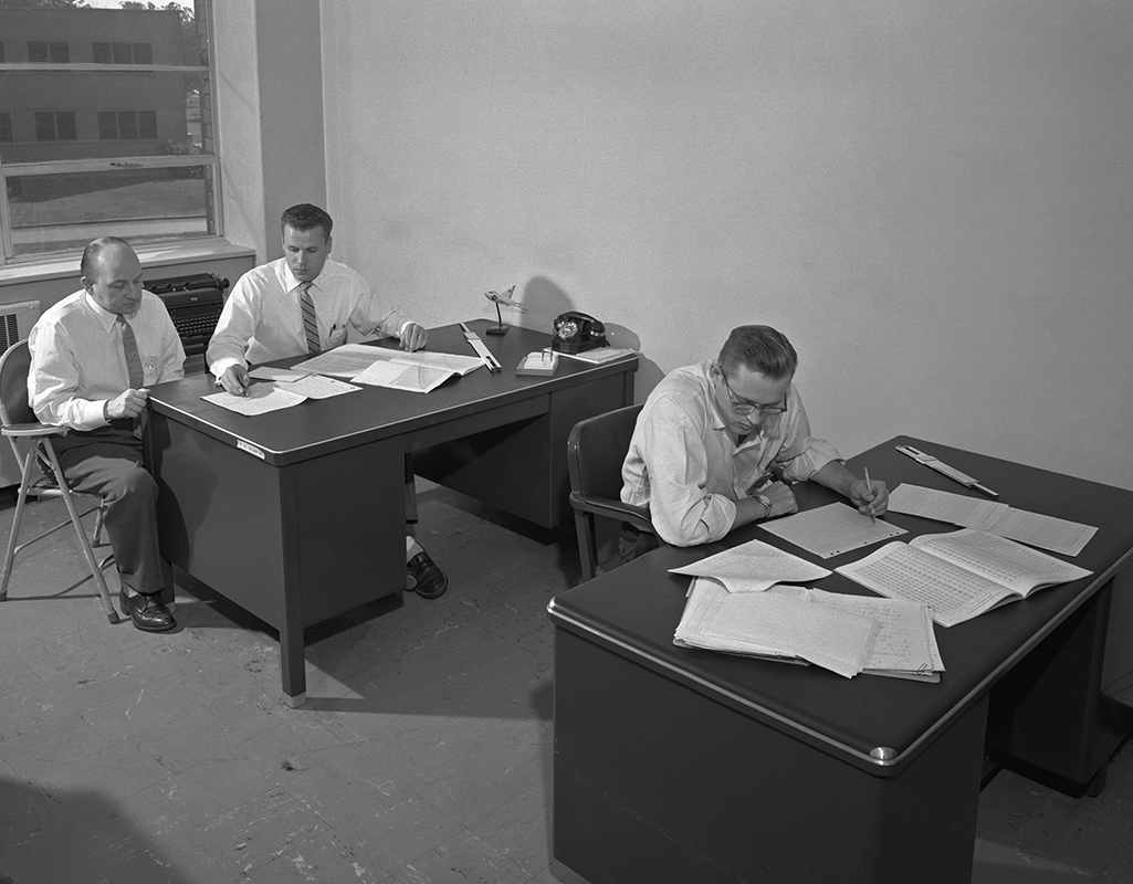 Three engineers seated at desks.