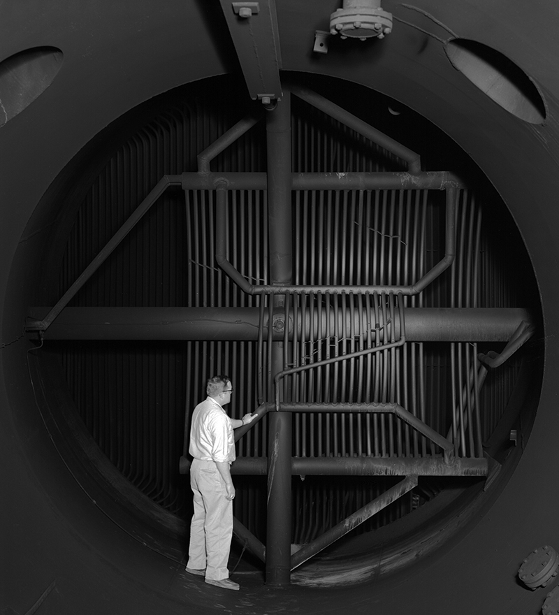 Man inspecting interior of cooling equipment.