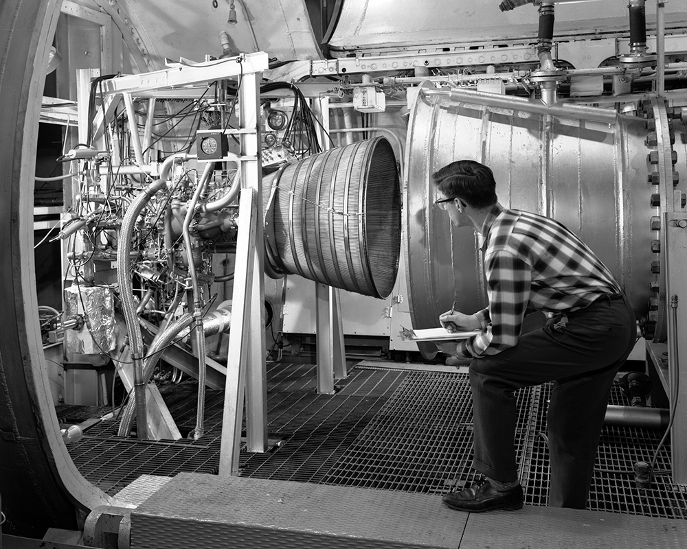 Man looking into rocket nozzle.