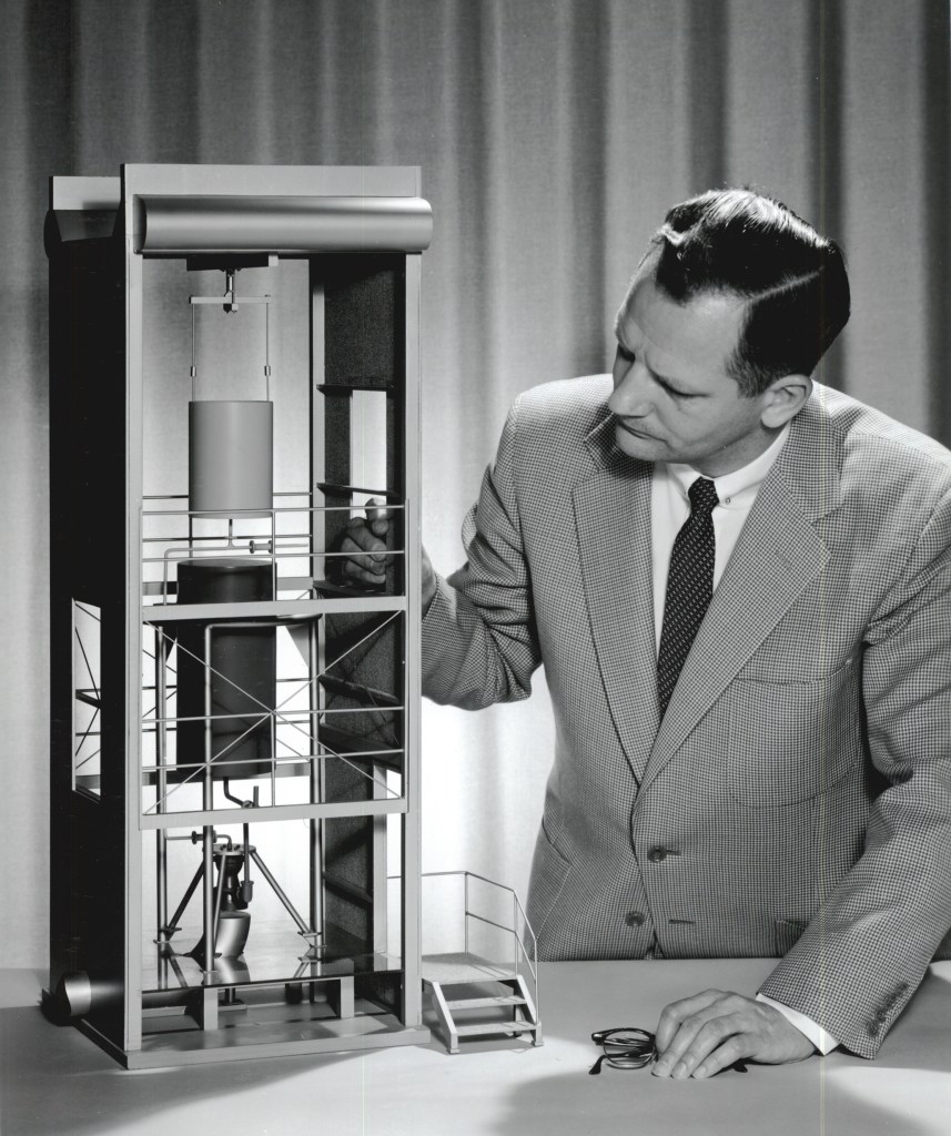 Man with model of J-2 facilty