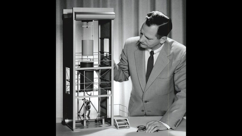 Man with model of J-2 facilty