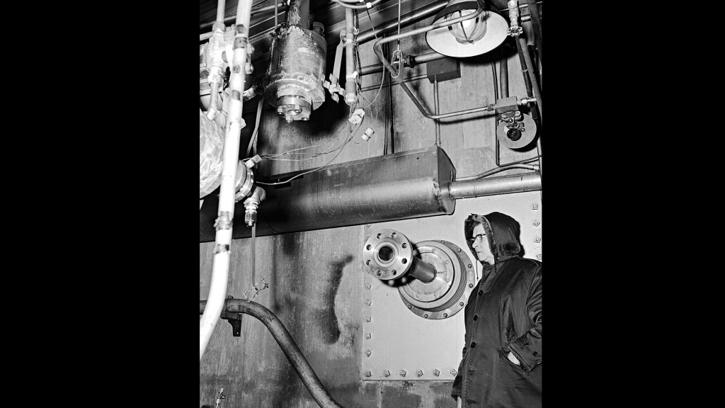 Man examines piping inside D Site.