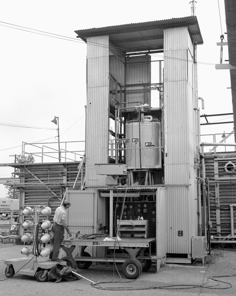 A technician inspects the installation of an experimental arc tank at the J-4 vertical test stand