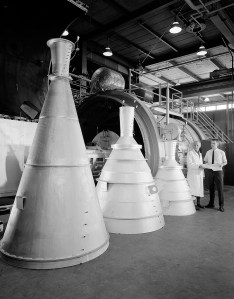 Three large rocket nozzles standing on floor.