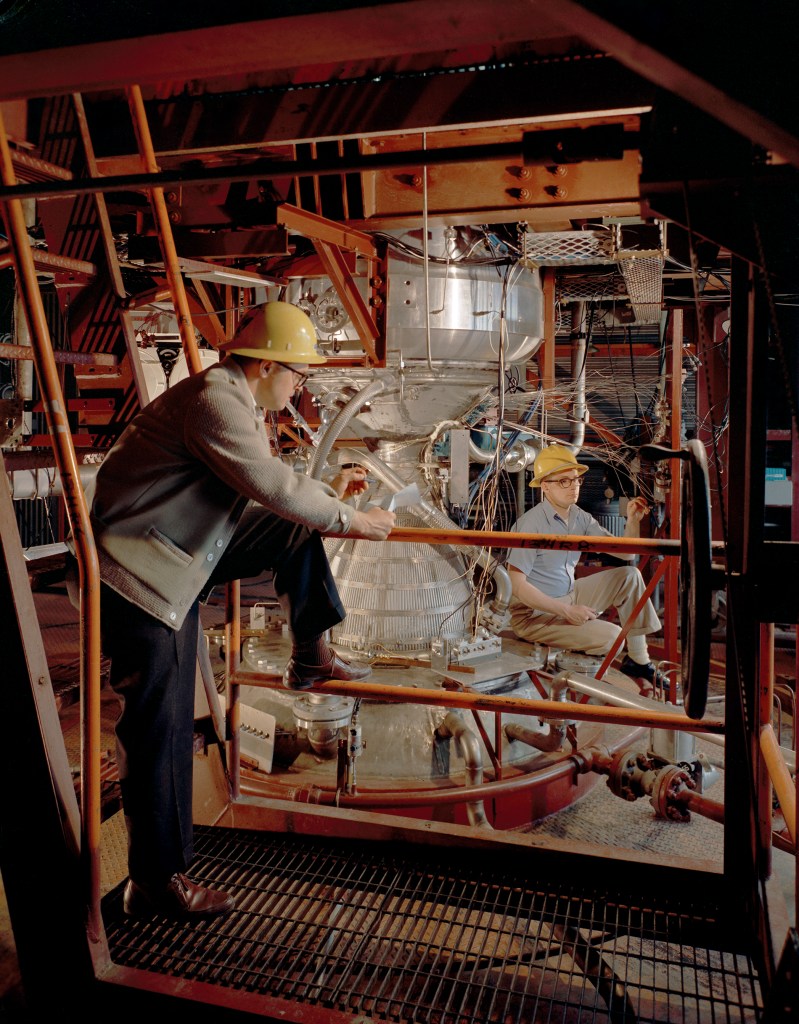 Two engineers examine Kiwi engine in B-1 stand