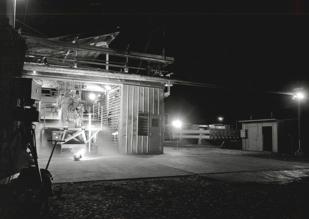 Rocket engine firing horizontally out of J-1 at night