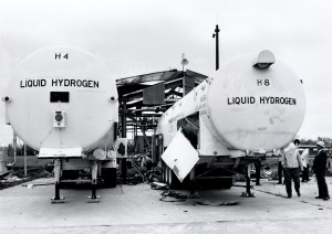 Two hydrogen trailers in front of burned out building.