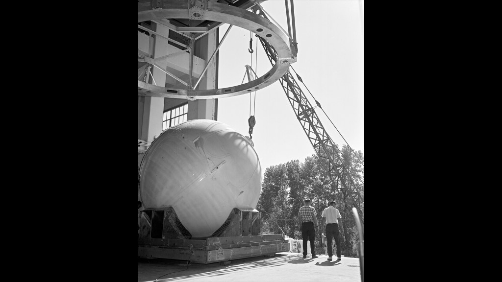 Crane lifting round tank.