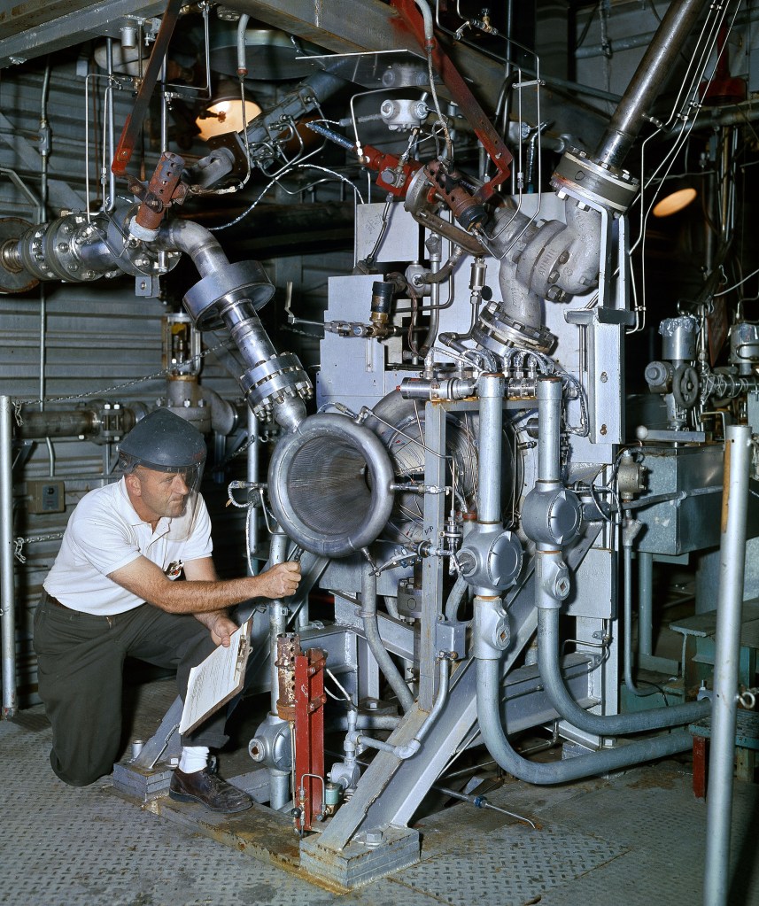 Technician working with engine inside J-1