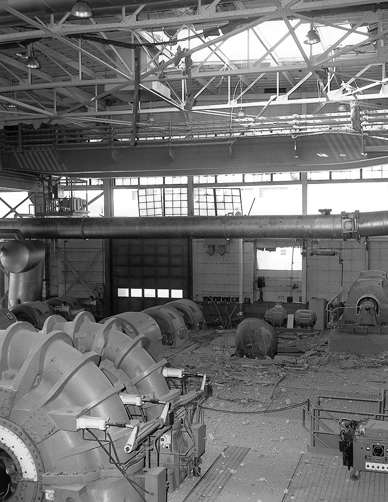Interior of building with broken windows and a hole in the roof.