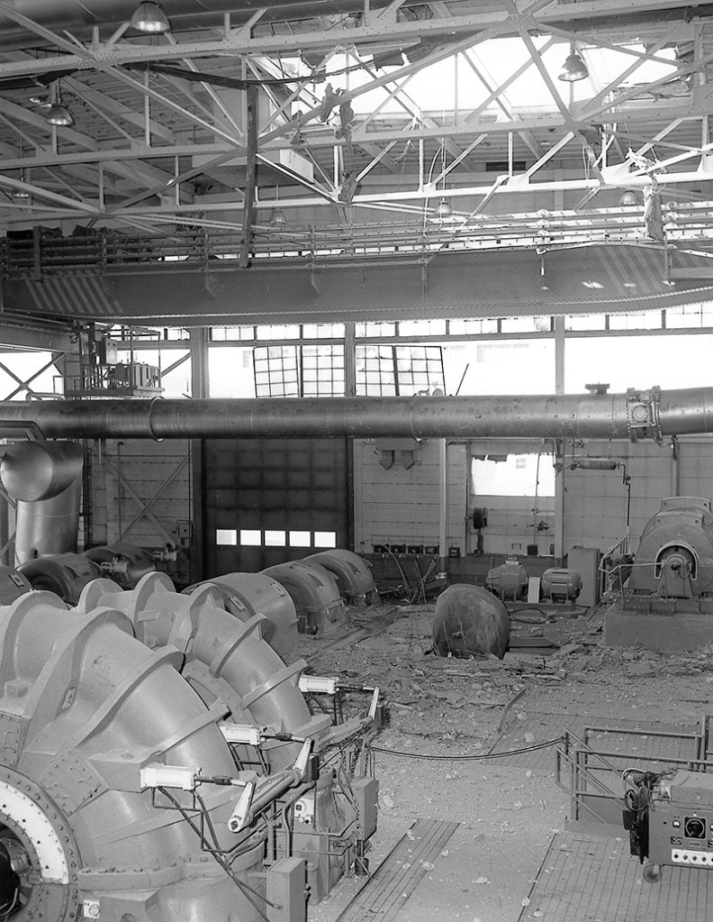 Interior of building with broken windows and a hole in the roof.