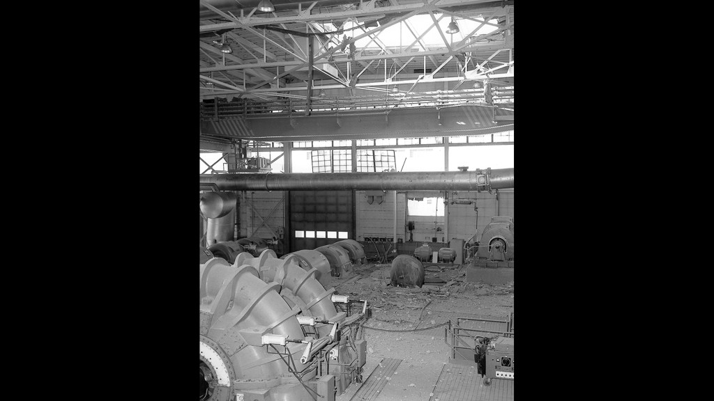 Interior of building with broken windows and a hole in the roof.