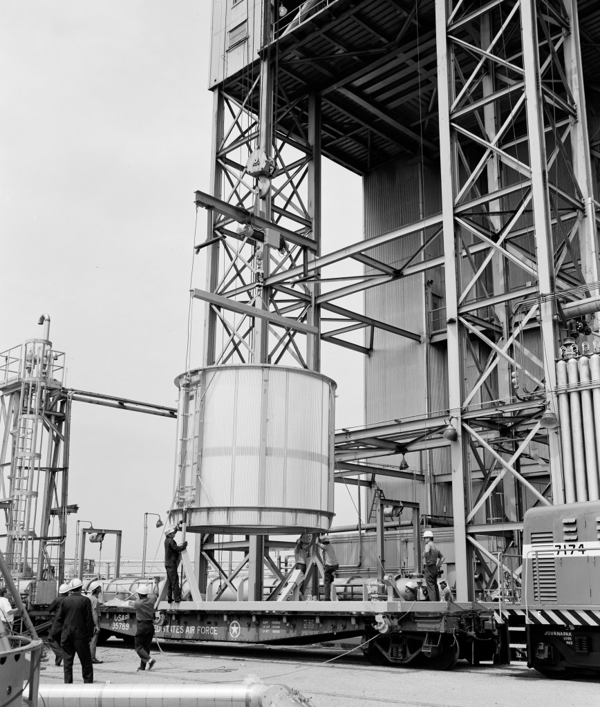Ground-level view of crane lifting test article into B-3