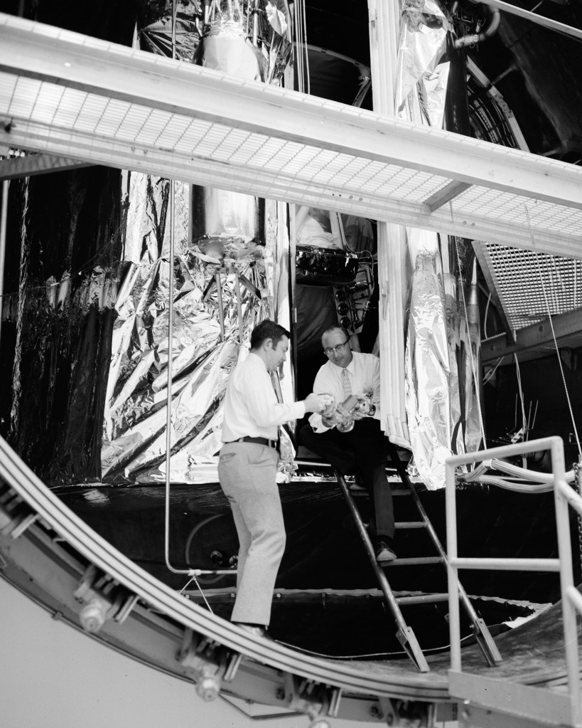 Two researchers examine cryoshroud in open K Site chamber