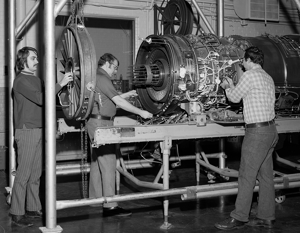 Men working on engine on stand.