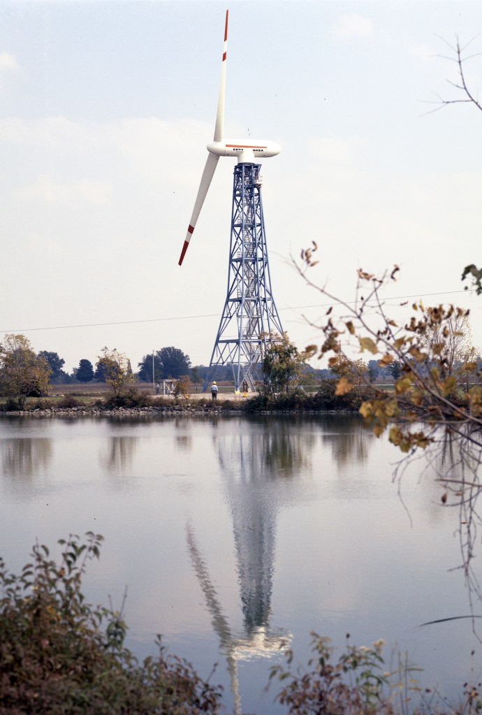View across pond of wind turbine