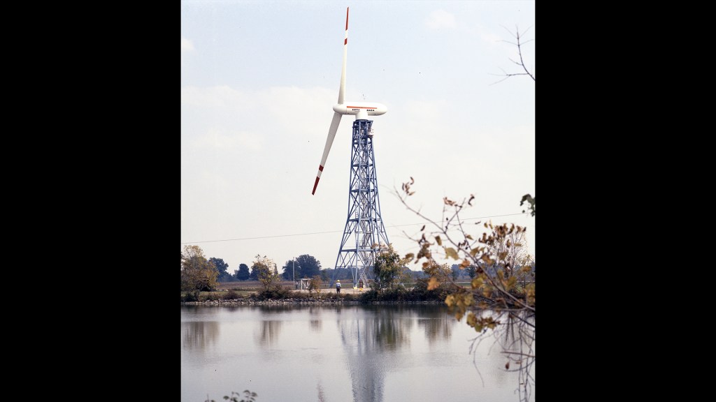 View across pond of wind turbine