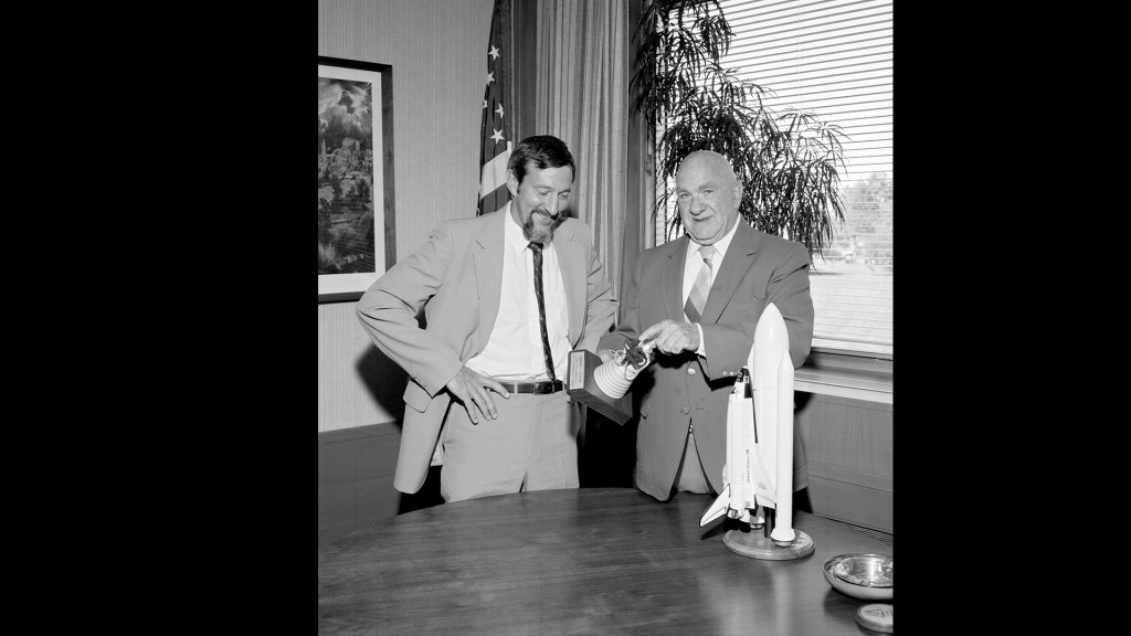 Two men looking at model.