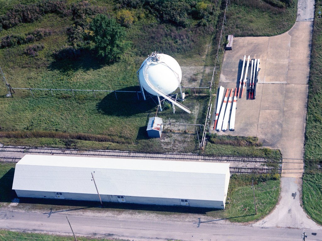 Aerial view of the B-1 site showing wind turbine blades on ground.