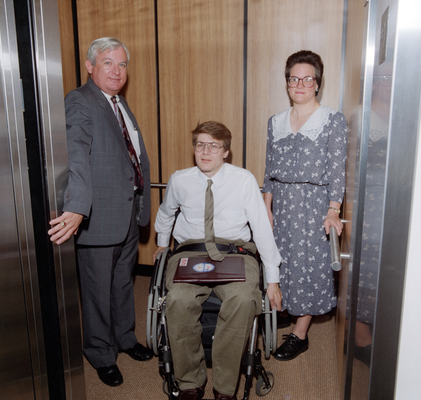 Three people in elevator.