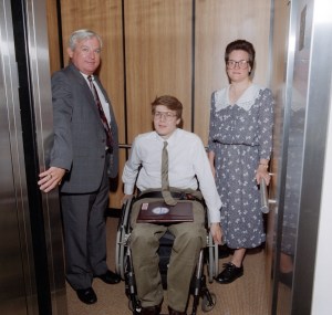 Three people in elevator.