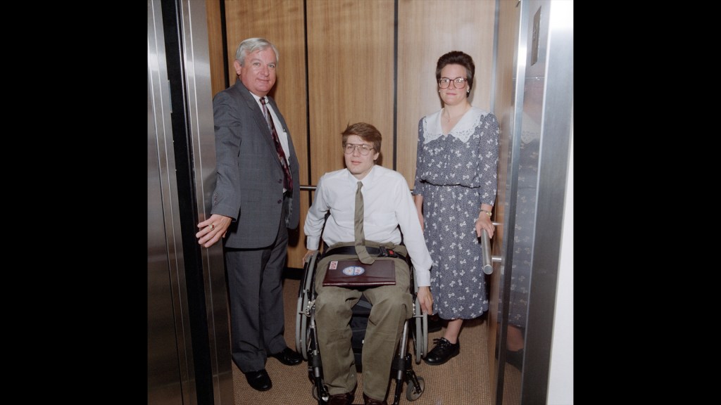 Three people in elevator.