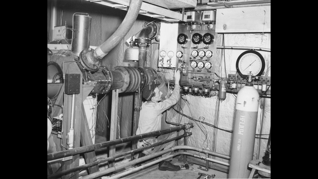 Two mechanics prepare a test rig inside the Pilot Plant