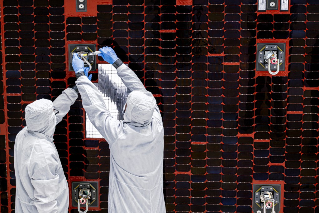 A close-up of technicians working on a Roman solar panel