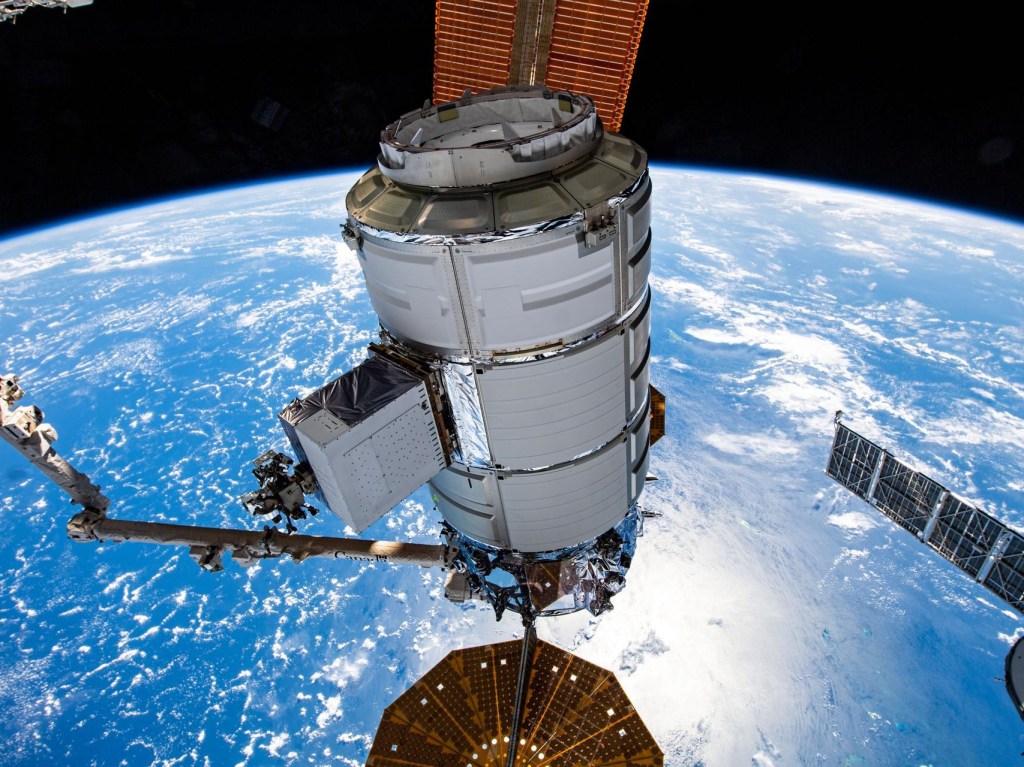Commercial Cargo Spacecraft in space above the Earth.
