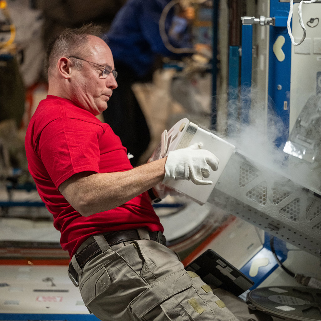 NASA astronaut and Expedition 73 Flight Engineer Mike Fincke inserts a cryogenic storage unit, called a dewar, containing blood samples collected from a crew member into a science freezer for preservation and later analysis. The Minus Eighty-Degree Laboratory Freezer for International Space Station, or MELFI, is a research freezer that maintains experiment samples at ultra-cold temperatures in microgravity.