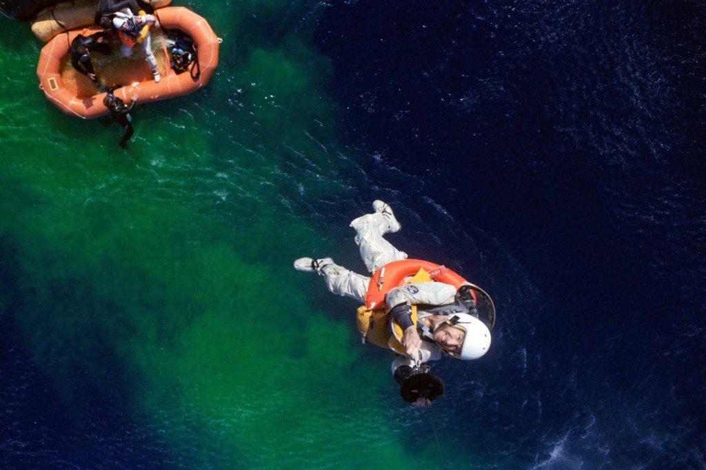 View from above of Jim Lovell being hoisted up to the recovery helicopter.