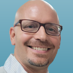 Profile photo of Bruce White in front of a blue background.