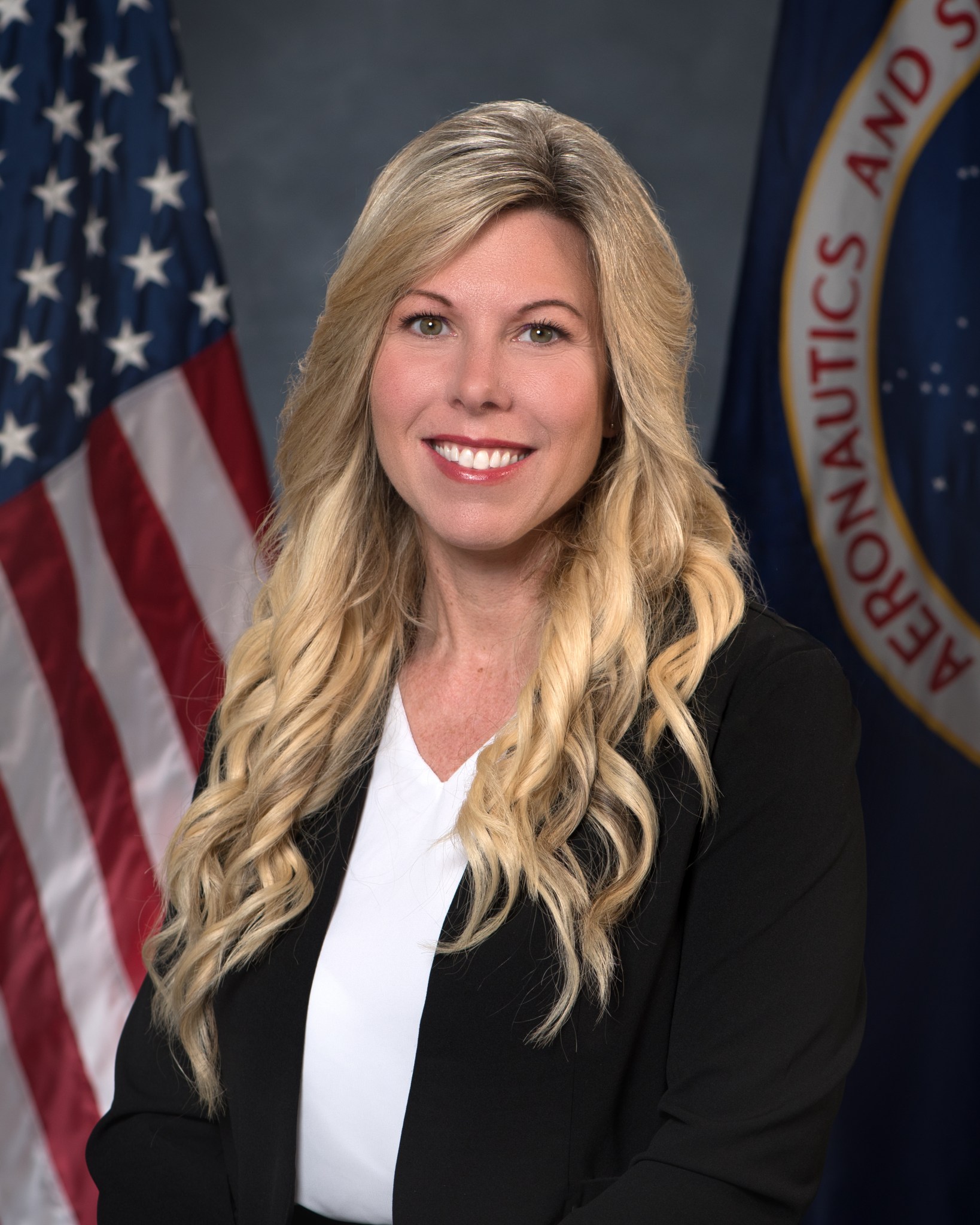 Portrait of Lindsay Kaldon with American and NASA flags behind her.