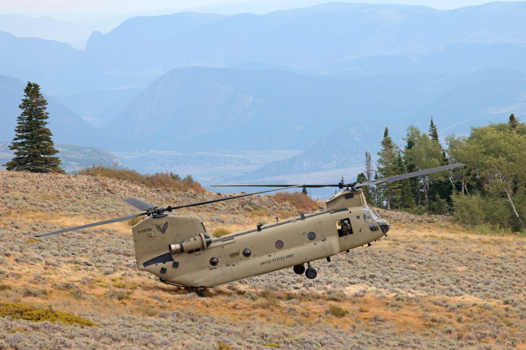 A member of the Colorado Army National Guard looks out of a CH-47 Chinook as it lands at a steep angle Aug. 29. A crater on the Moon could have a similar incline, posing landing challenges for future crewed Artemis missions.