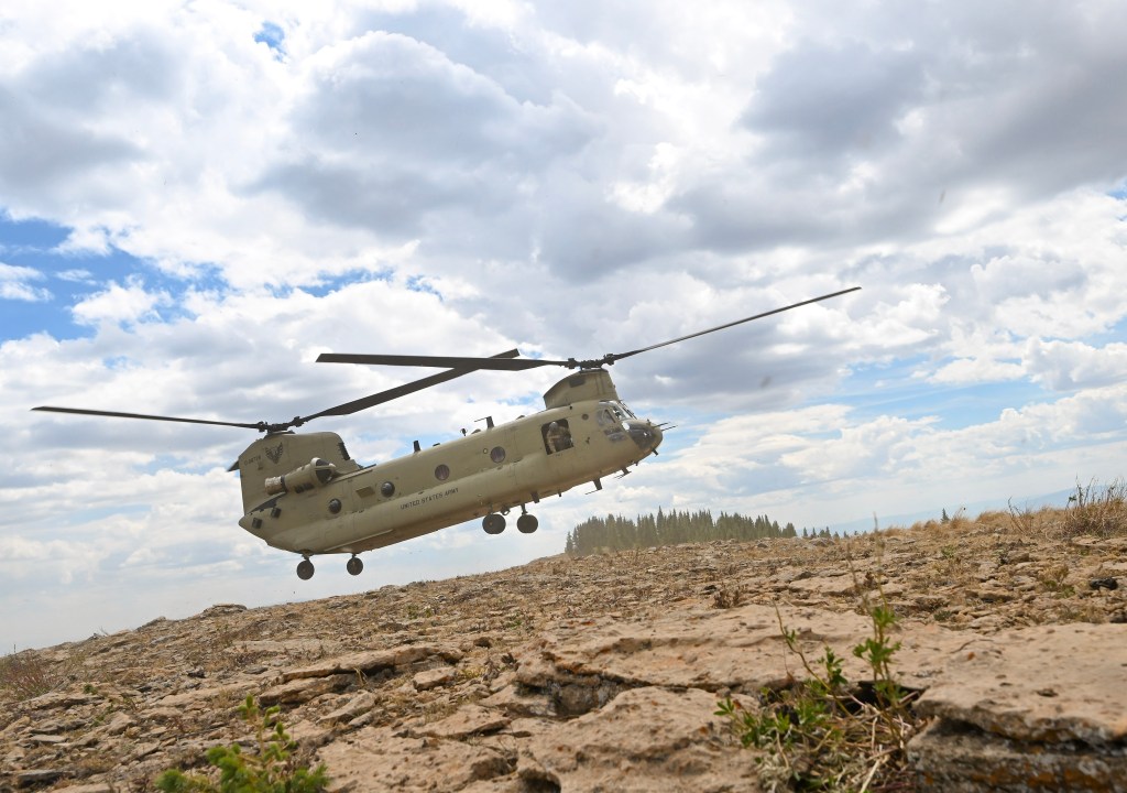 A member of the Colorado Army National Guard peers out of a CH-47 Chinook in preparation for landing Aug. 22. NASA and trained instructors from the Army National Guard use a range of aircraft during flight training. Chinooks are used to demonstrate challenges with landing on the Moon.