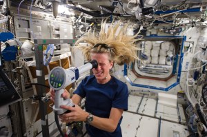 Astronaut Karen Nyberg is seen floating in the space station. Karen is looking into a device to measure ocular health.