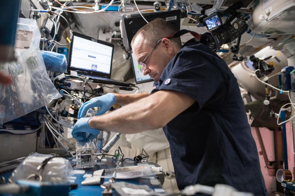 NASA astronaut Ricky Arnold leans over and looks down towards the left at his microbe samples as he swabs his lab samples.