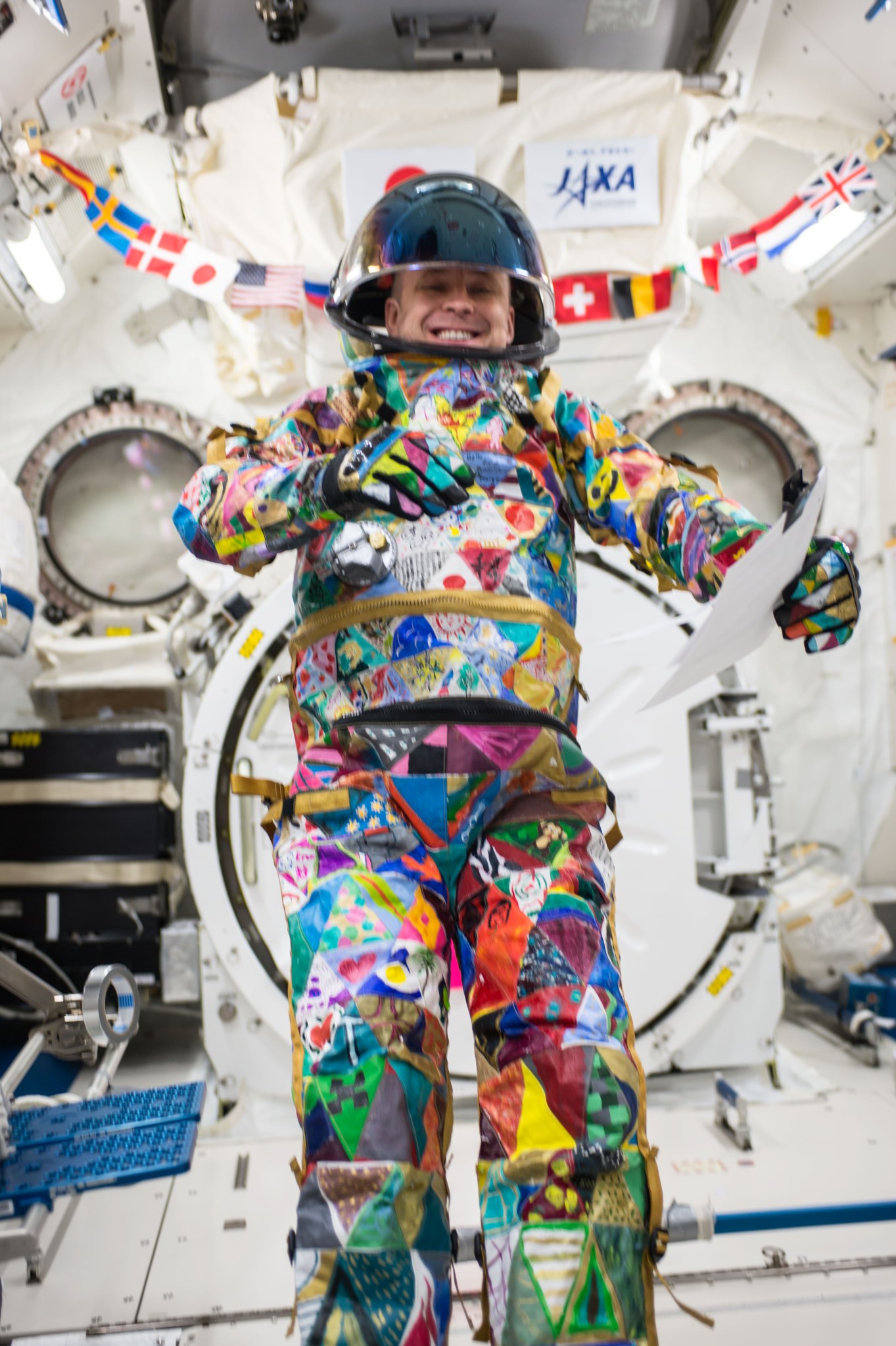 An image of an astronaut aboard the space station wearing a colorful spacesuit.