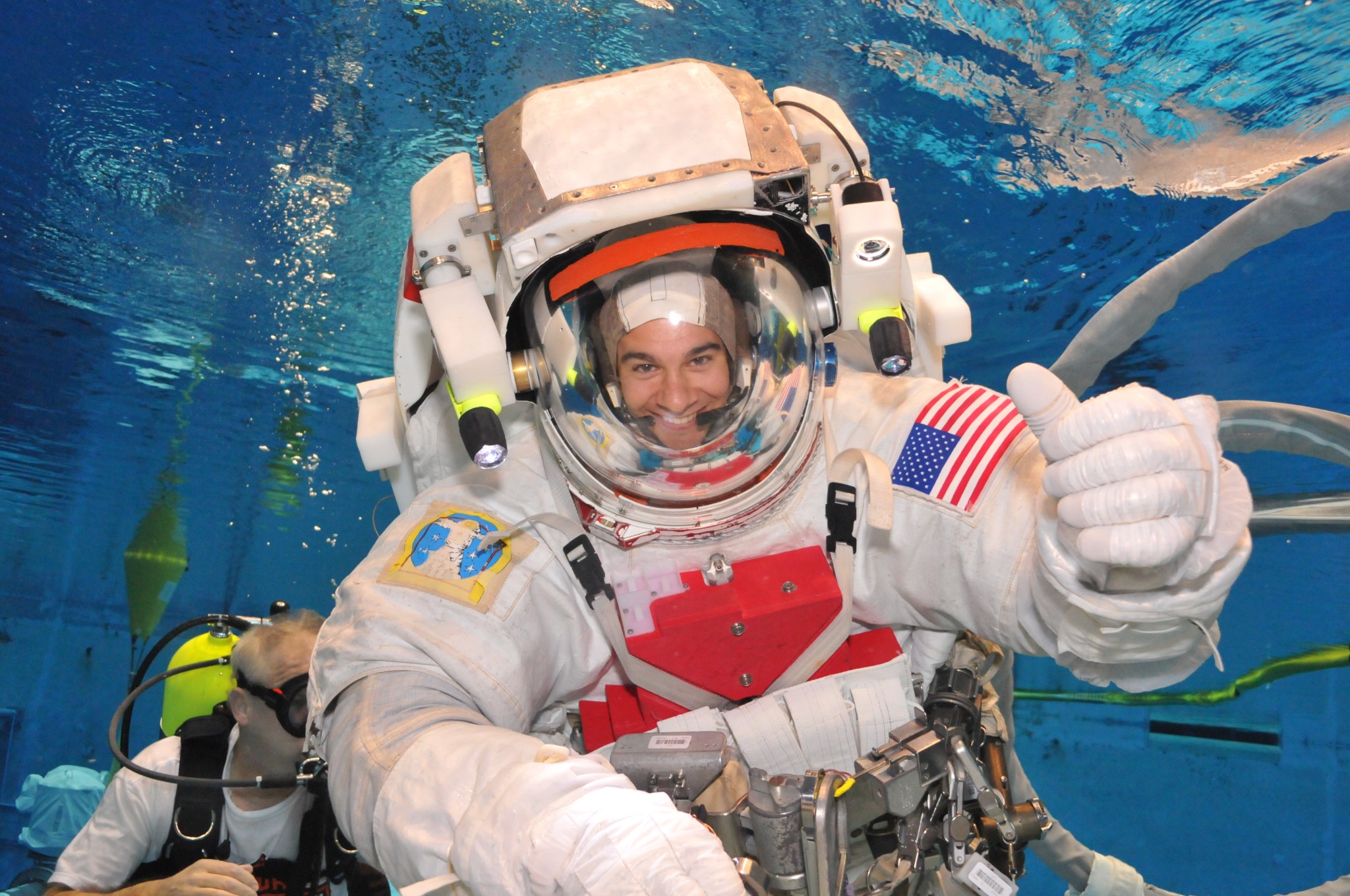 A man wears a full spacesuit underwater while conducting a test dive at NASA's Neutral Buoyancy Laboratory.