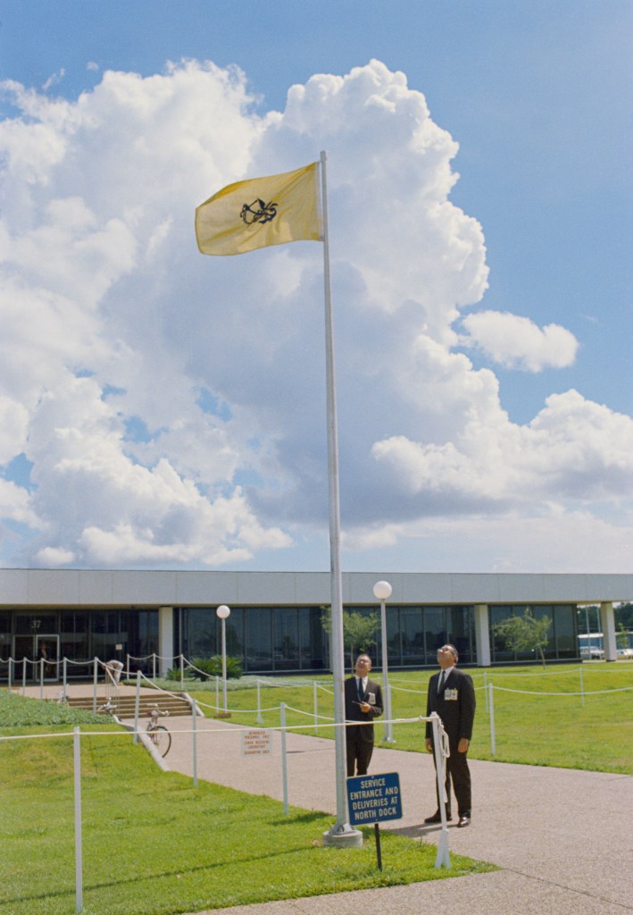 Dr. Charles A. Berry, Director, Medical Research and Operations, and Dr. Walter W. Kemmerer, Chief, Preventive Medicine Div., are pictured looking at the Quarantine Flag being flown outside the Bldg. 37 Lunar Receiving Laboratory where the Apollo 11 Astronauts are temporarily housed.