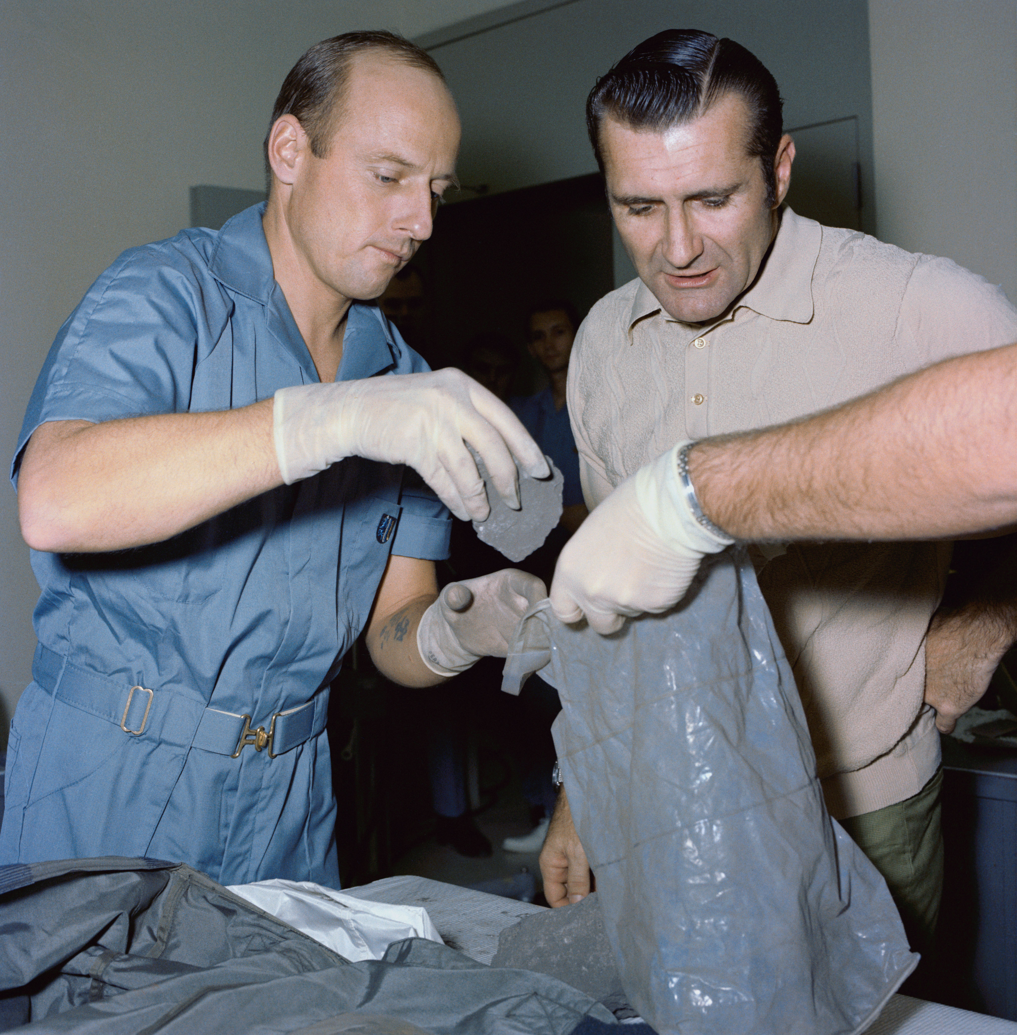 View of Apollo 12 crew removing Surveyor Spacecraft parts from the tote bag in the Lunar Receiving Lab, Bldg # 37. Astronauts Charles Conrad and Richard F. Gordon