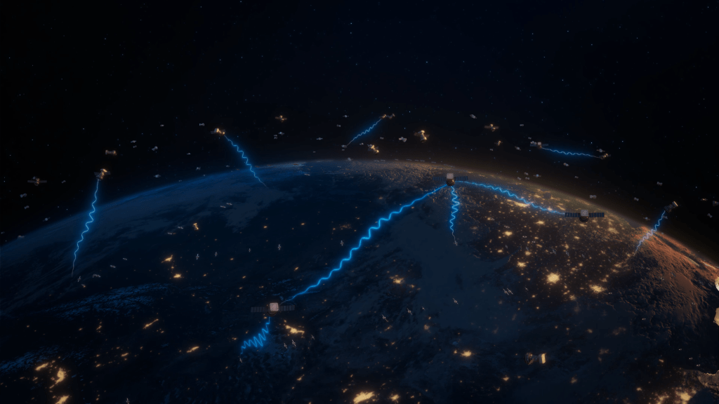 An artist's illustration of a near-Earth satellite relay network, with dozens of small satellite floating in space above Earth. We see half of the Earth in the bottom half of the image, lit up at night with lights around the globe. The satellites are sending bright blue waves of light to each other and back down to Earth, representing invisible communications signals traveling through space, in front of a dark black star filled background. ​